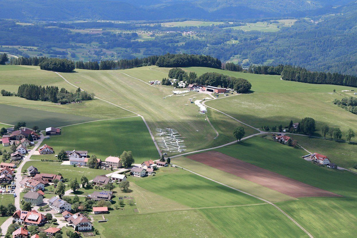 Eine Flugzeughalle. Eine ASK 21 mit geöffneter Haube. Auf dem Sitz liegt ein Plakat der Sendung mit der Maus. Aufschrift: Türen auf am 3. Oktober.